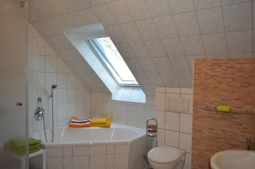 a bathroom with a tub and a toilet and a skylight at Ferienhaus Sonne in Cottbus
