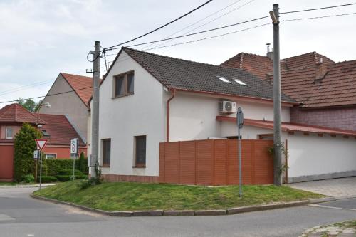 a white house with a fence and some houses at Apartmán-Hovorany in Hovorany