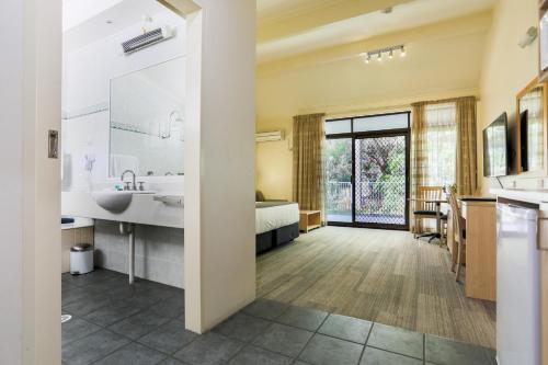 uma grande casa de banho com um lavatório e uma banheira em Parkhaven em Nowra