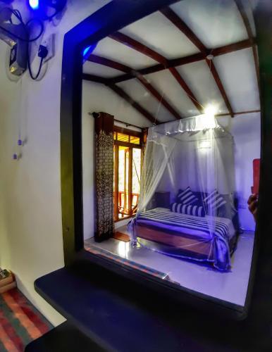 a mirror reflection of a bed in a room at Cozy Homestay Waterfall Road Ella in Ella