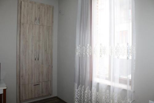 a window with a curtain and a dresser in a room at Guest House Lviv Грузия in Kutaisi