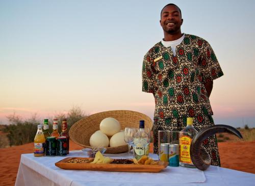 a man standing next to a table with eggs on it at Bagatelle Kalahari Game Ranch in Hardap