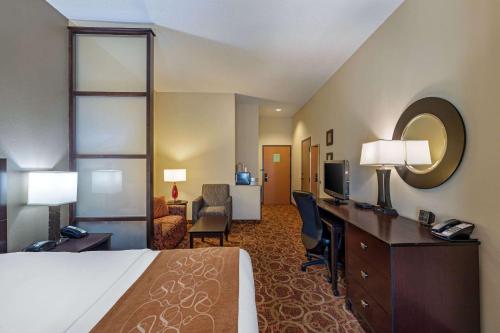 a hotel room with a bed and a desk at Comfort Suites McKinney-Allen in McKinney
