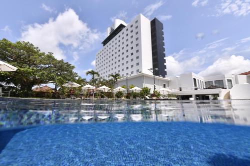 un hôtel avec une piscine en face d'un bâtiment dans l'établissement Art Hotel Ishigakijima, à Ishigaki
