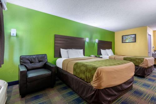 una habitación de hotel con 2 camas y una silla en Econo Lodge, en Nashville