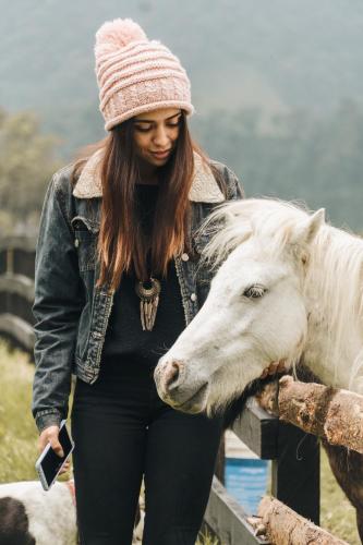 a woman is standing next to a white horse at Hostal La Laguna in Villamaría