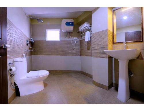 a bathroom with a white toilet and a sink at Udaan Olive Hotel & Spa, Pelling in Pelling