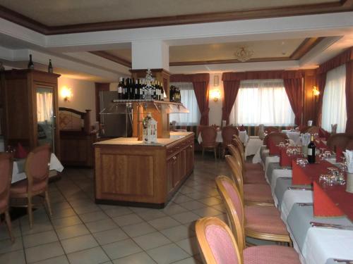 un comedor con mesas y sillas y un bar en Hotel Fiorenza, en Campitello di Fassa