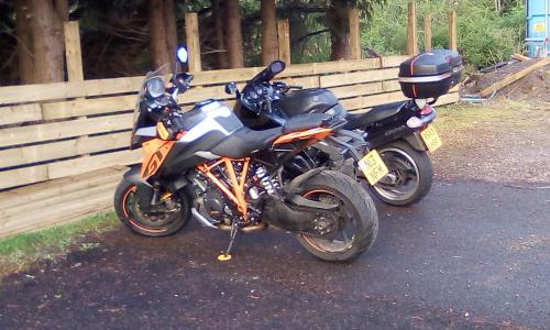 a motorcycle parked on the street next to a fence at The Townhouse Self Catering in Dumfries
