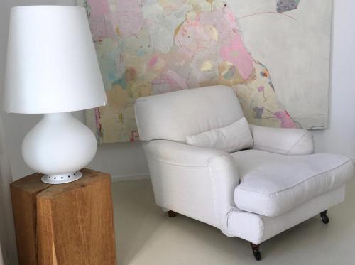 a white chair and a lamp on a wooden table at Het Zwaantje in Londerzeel