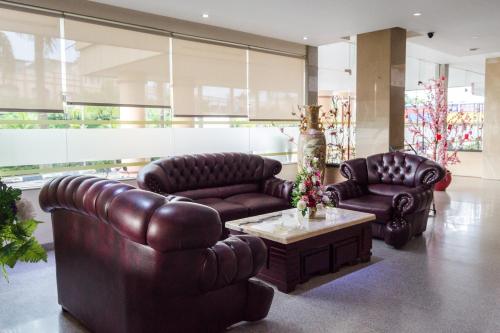 a living room with two leather couches and a coffee table at Aviari Hotel in Sekupang