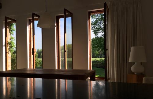 a dining room with a table and large windows at Het Zwaantje in Londerzeel