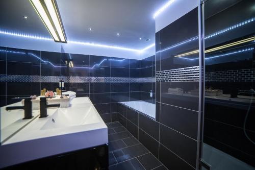 a bathroom with a sink and a tub and a mirror at Hôtel de France in Aix-en-Provence