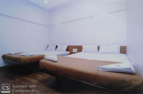 two beds sitting next to each other in a room at Rajhuns Deluxe Lodging in Kolhapur