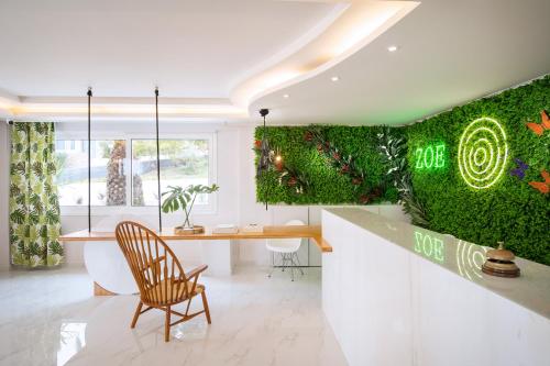 Zoe Hotel, Trypiti Beach Resort & Hive water park في يميناريا: مطبخ بحائط أخضر مع طاولة وكراسي