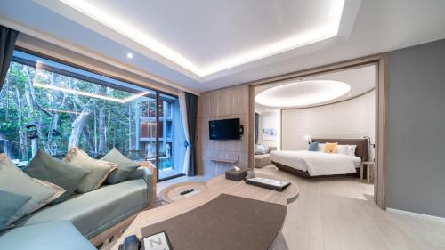 a living room with a couch and a bed at The Nature Phuket - SHA Extra Plus in Patong Beach