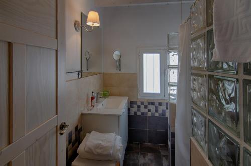 Baño pequeño con lavabo y espejo en Casas Rurales Prunus Avium, en Cambrón