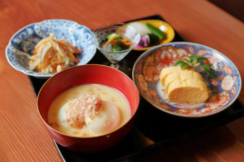 een dienblad met kommen eten en een kop soep bij Ryokan Tanoya in Kyoto