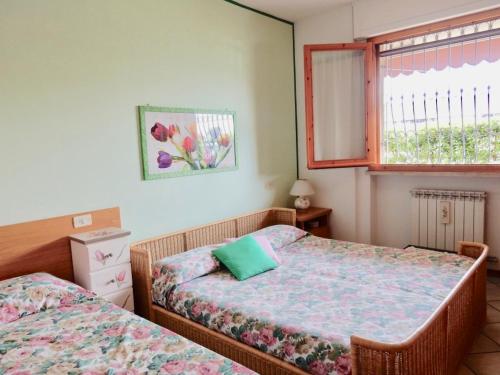 Un dormitorio con dos camas y una ventana. en Appartamento Le Mimose, en Viareggio