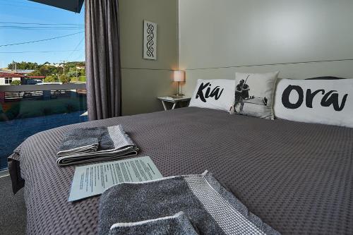 ein Schlafzimmer mit einem Bett mit einer Decke und einem Fenster in der Unterkunft WanaHaka - Lake Wanaka & Town at your door in Wanaka