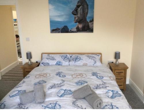 1 dormitorio con 1 cama con una foto en la pared en 3 Park View en Barmouth