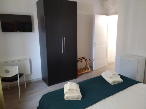 a bedroom with a bed with two towels on it at ARNO ROOMS VERONA in Verona