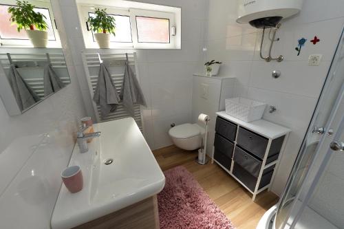 Baño blanco con lavabo y aseo en Apartment Simoni ZD, en Zadar