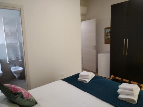 a bedroom with a bed and a bathroom with a sink at ARNO ROOMS VERONA in Verona