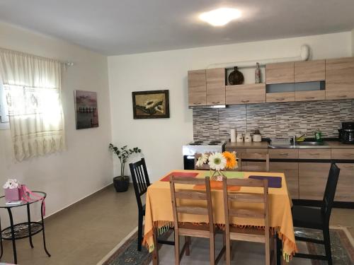 een keuken en eetkamer met een tafel en stoelen bij Armonia Apartment in Plataria