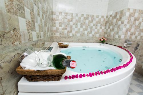 a bathroom with a bath tub with a bottle of champagne at Hotel Earth Light Sauraha in Chitwan
