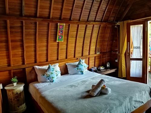 a bedroom with a bed in a wooden room at Ginanthi Cottage in Nusa Penida