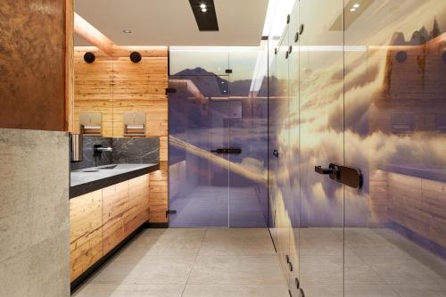 a bathroom with a shower with a glass door at Hotel Tirol in Ischgl