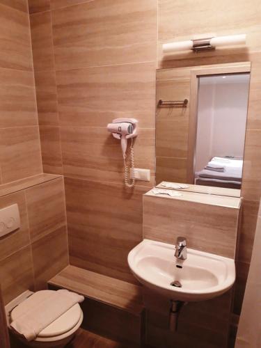 een badkamer met een wastafel, een toilet en een spiegel bij LV Rooms & Apartments am Lützowplatz in Berlijn