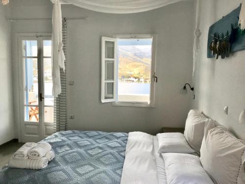a bedroom with a bed and a window at Amfitriti Serifos in Livadion