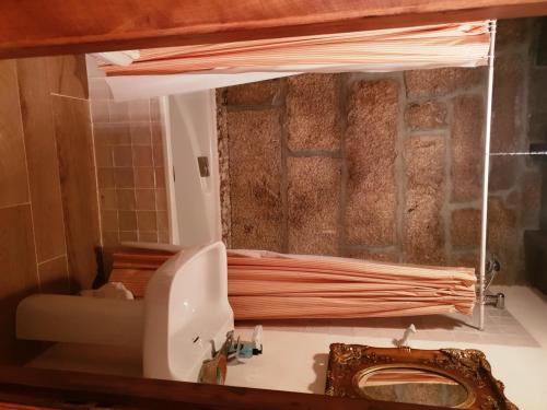 a bathroom with a sink and a toilet and a mirror at Pazo de Turbisquedo in Turbisquedo