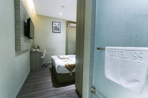 a small room with a bed and a towel on a door at Hotel 99 Kepong in Kuala Lumpur