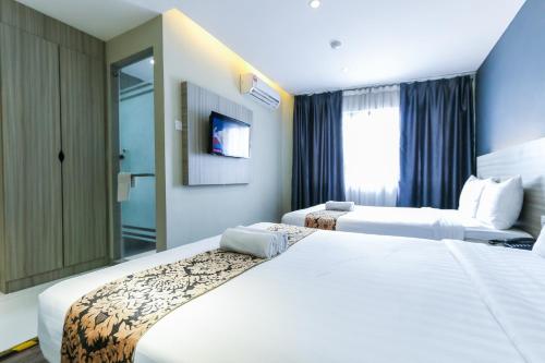 a hotel room with two beds and a tv at Hotel 99 Kepong in Kuala Lumpur