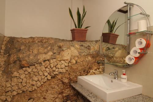 a bathroom with a sink and a stone wall at Greenyard Inn in Boracay