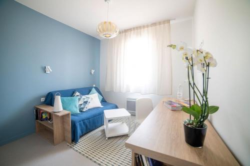 - un salon avec un canapé bleu et une table dans l'établissement Hotel Enight, à Gradignan