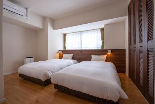 sypialnia z 2 łóżkami i oknem w obiekcie Lieta Nakayama w mieście Nago