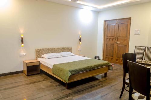 a bedroom with a bed and a wooden door at Malhar Villa -Kashid in Kashid
