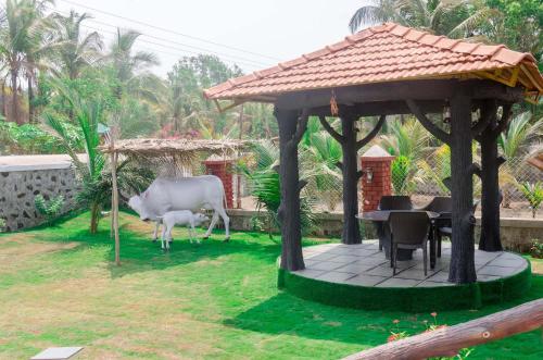 a gazebo with a table and chairs in a yard at Malhar Villa -Kashid in Kashid