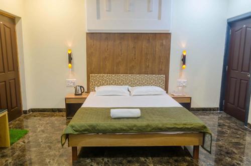 a bedroom with a large bed with two night stands at Malhar Villa -Kashid in Kashid