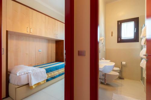 uma pequena casa de banho com uma cama e um lavatório em Delle Rose em Cavallino-Treporti