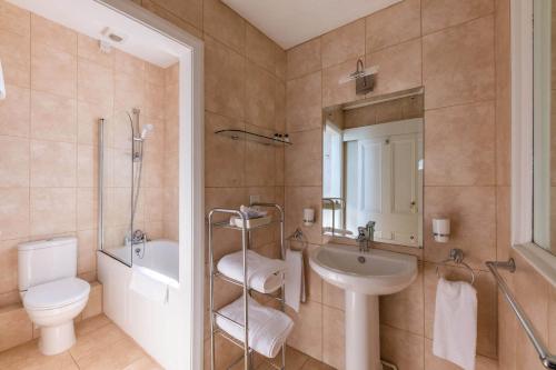 a bathroom with a sink and a toilet and a shower at The White Hart Hotel in Moretonhampstead