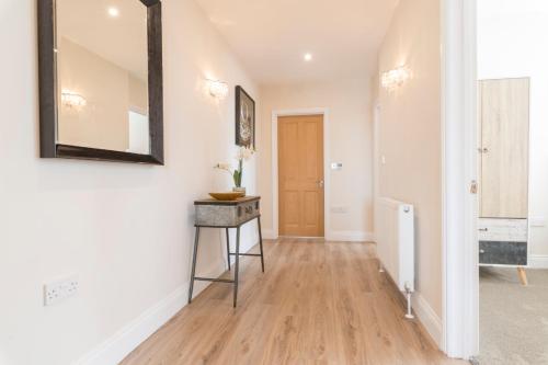 a hallway with a mirror and a wooden floor at South Quay Penthouse - 2 Bed in Great Yarmouth