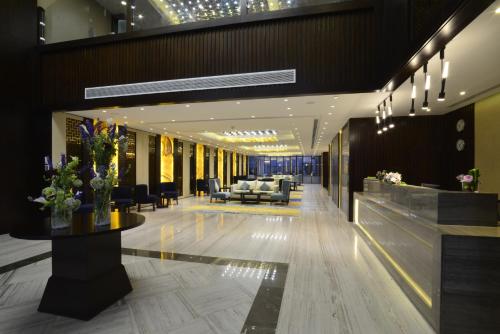 a lobby with couches and chairs in a building at Naviti Warwick Dammam in Dammam