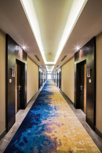 a hallway with a blue carpet in a building at Naviti Warwick Dammam in Dammam