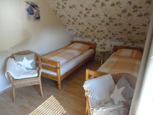 a small room with two beds and a chair at Ferienwohnung Schneemann in Hohegeiß