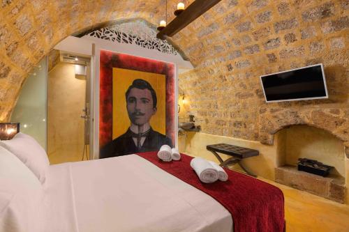 a bedroom with a bed with a painting of a man at 10GR Boutique Hotel & Wine Bar in Rhodes Town